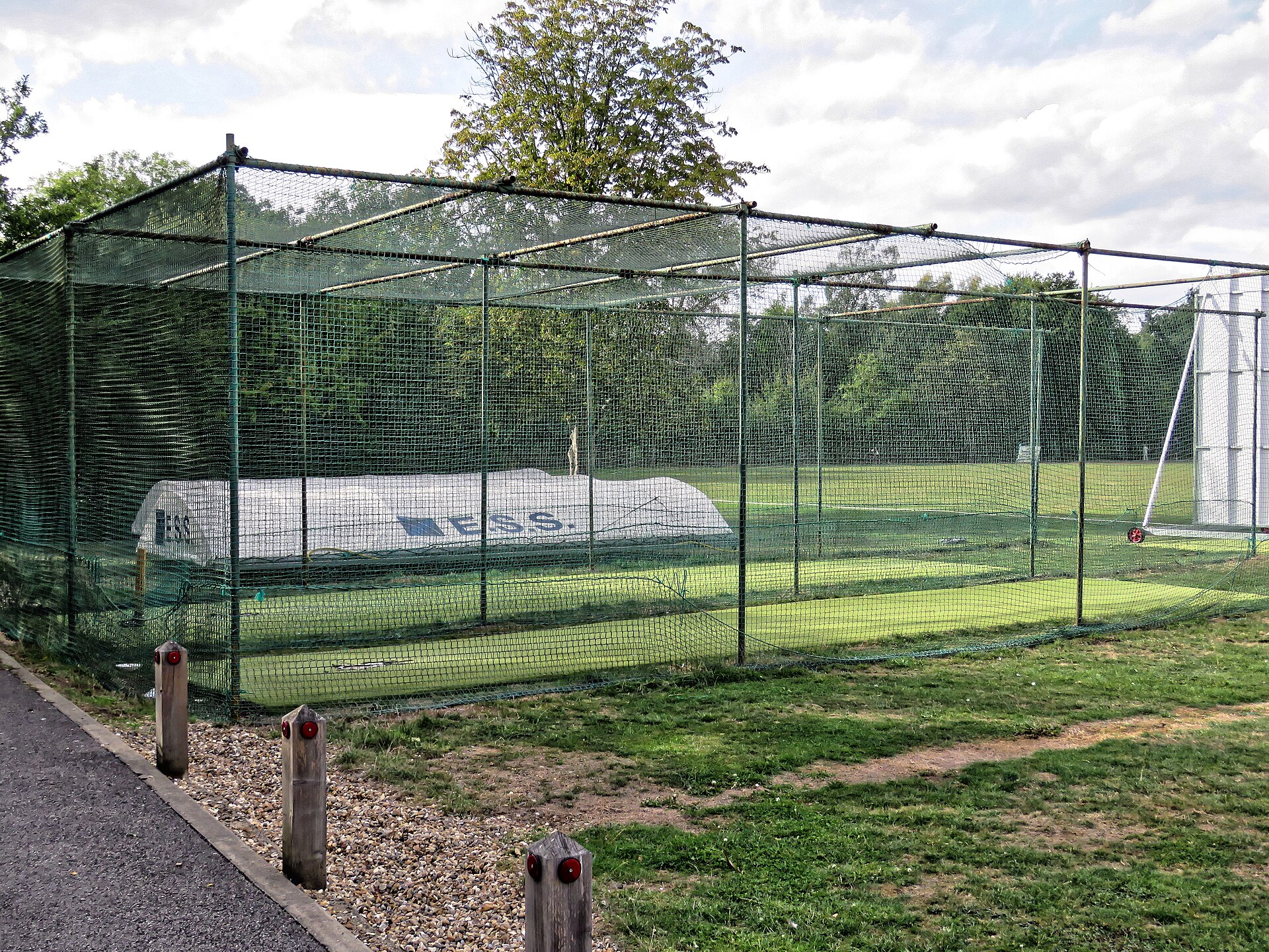 Outdoor cricket practice nets with a covered pitch at a club ground